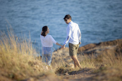 Rear view of couple standing on shore
