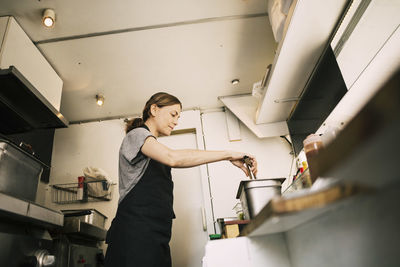 Low angle view of woman preparing food in truck