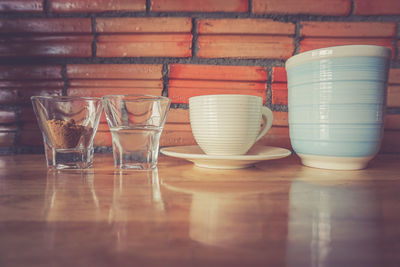 Close-up of drinking glasses and cup on table