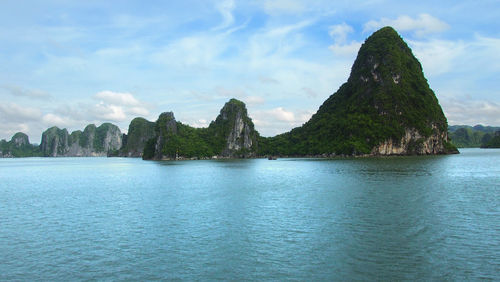Scenic view of sea and mountains against sky