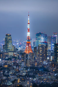 Illuminated buildings in city against sky at night