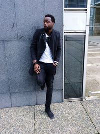 Portrait of young man standing on wall