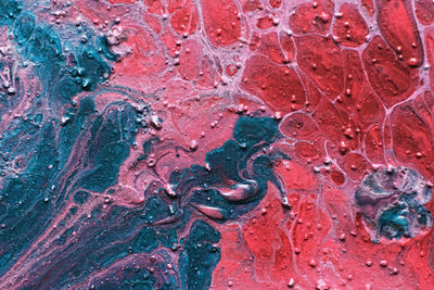 Fluid art. embossed strokes, craters and drips of red and green paint. marble effect background or