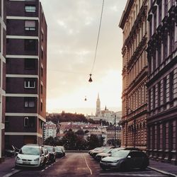 Cars on street in city against sky