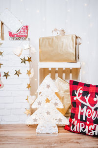 Christmas decoration at home. chimney, gifts, tree, noel, cushions on beautiful indoor white studio.