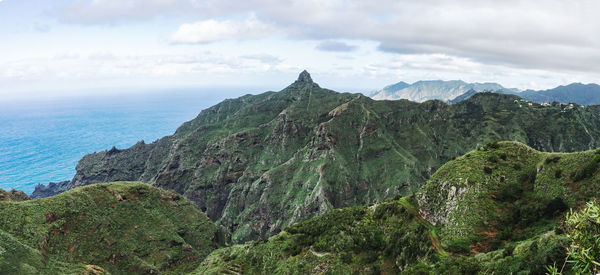 Scenic view of sea and mountains against sky