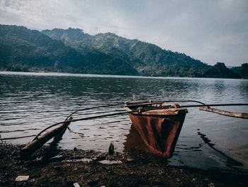 Scenic view of lake by mountains against sky