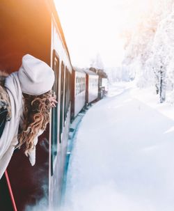 Woman peeking through window during winter