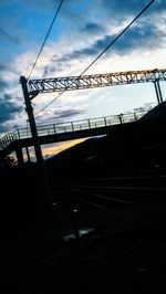 Low angle view of silhouette railroad tracks against sky during sunset