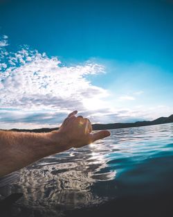 Close-up of hand against river