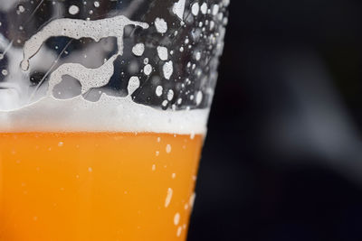 Close-up of beer glass against black background