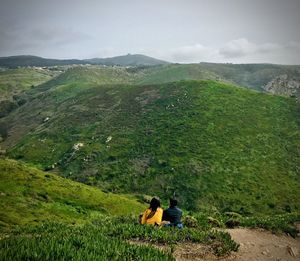 Rear view of people looking at mountain landscape