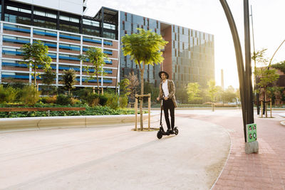 Full length of man skateboarding on city street