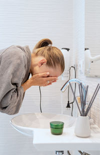 Womens health. spa and wellness. woman washing her face in the bathroom