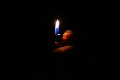 Close-up of lit candle in dark room