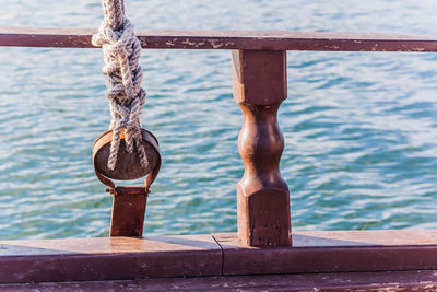 Close-up of padlock hanging on railing against river