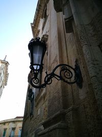 Low angle view of electric lamp against sky