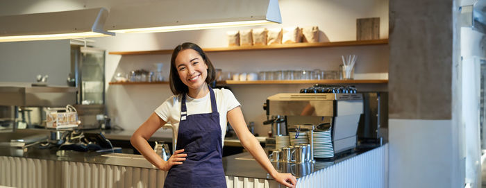 Portrait of young woman standing at home