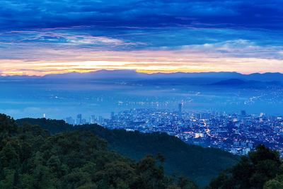 Aerial view of cityscape against sky at sunset