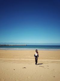 Full length of woman on beach against clear sky