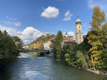 Bridge over river amidst buildings against sky