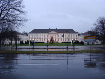 Building by lake against sky