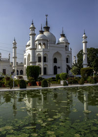 Reflection of church in water against sky