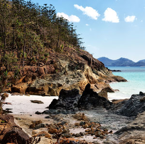 Rock formation on beach against sky