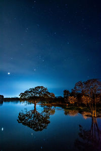 Scenic view of lake against sky at night