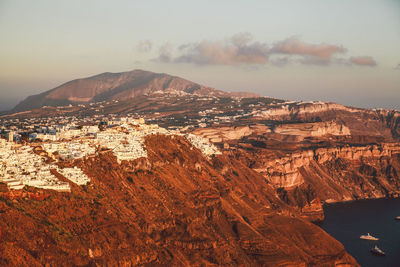 Buildings on mountain against sky at santorini