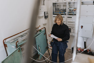 Smiling female electrician at work