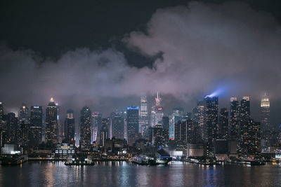 Illuminated buildings in city against sky at night