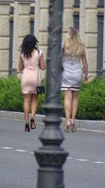 Rear view of girl walking on road