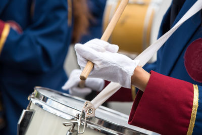 Midsection of person playing drum during parade