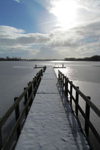 Pier over lake against sky