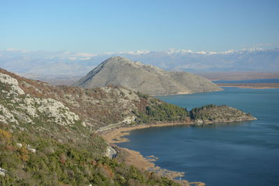 Scenic view of sea and mountains against sky