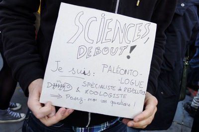 Midsection of student with banner protesting on street