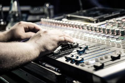 Cropped hands of man adjusting sound mixer