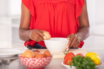 Midsection of woman holding food on table at home