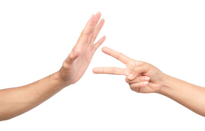 Cropped image of hand playing rock paper scissors against white background