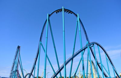 Low angle view of ferris wheel against clear blue sky