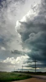 Scenic view of field against cloudy sky