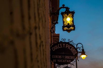 Low angle view of illuminated street light against sky