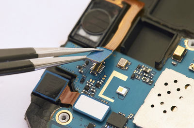 Close-up of tweezers on smart phone