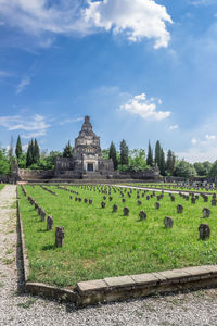 View of temple on field against cloudy sky