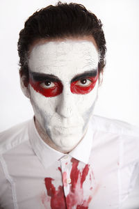 Man with white mascara and bloody in front of a white background