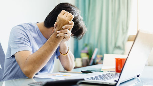 Rear view of man working on table