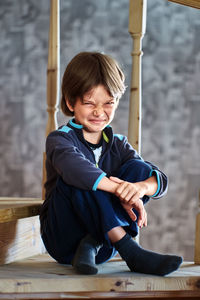 Portrait of boy sitting on staircase