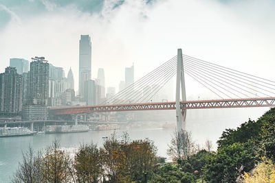 View of suspension bridge with city in background