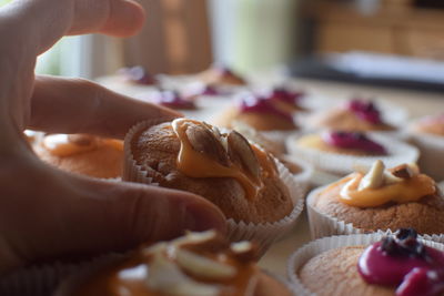 Close-up of hand holding cupcakes